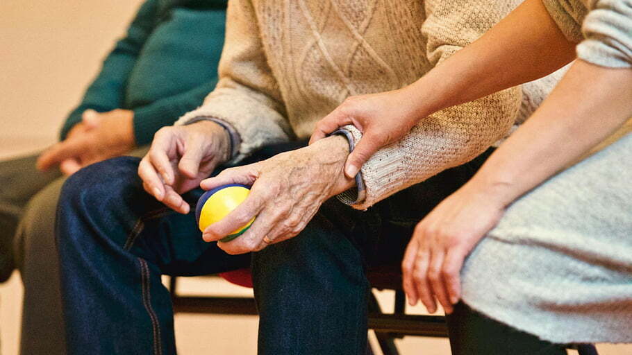 elderly-person-caregiver-holding-hands-stress-ball-indoor-setting-compassion-support-elderly-care-caregiver-support-stress-relief elderly-person-caregiver-holding-hands-stress-ball-indoor-setting-compassion-support-elderly-care-caregiver-support-stress-relief